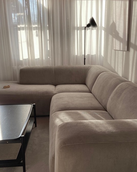 Диван честерфілд бежевий Елегантний бежевий диван честерфілд в класичному інтер'єрі з книжковими полицями