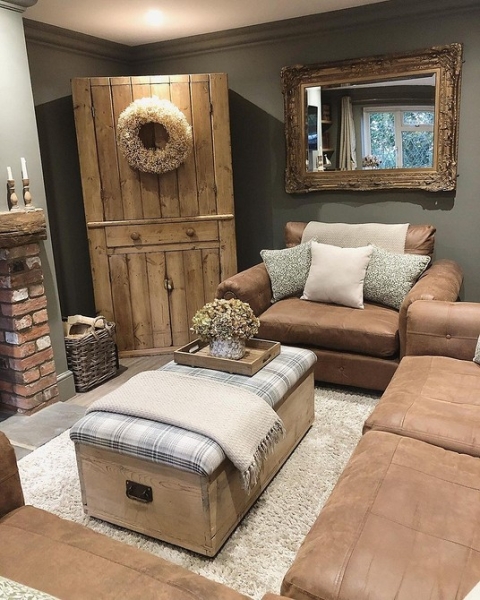 Затишок з коричневим диваном Коричневий шкіряний диван у вітальні з каміном, створює атмосферу затишку та тепла.