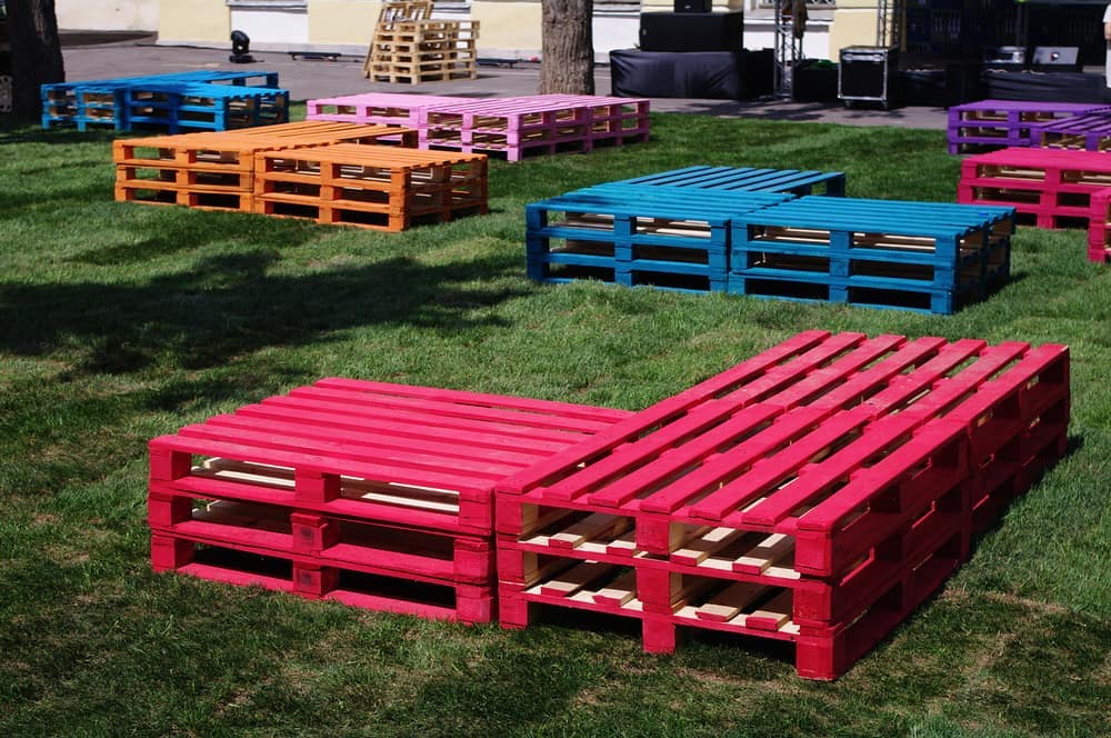 Веранда мрій Комфортні садові меблі з піддонів: крісла з м'якими сидіннями для відпочинку на веранді.