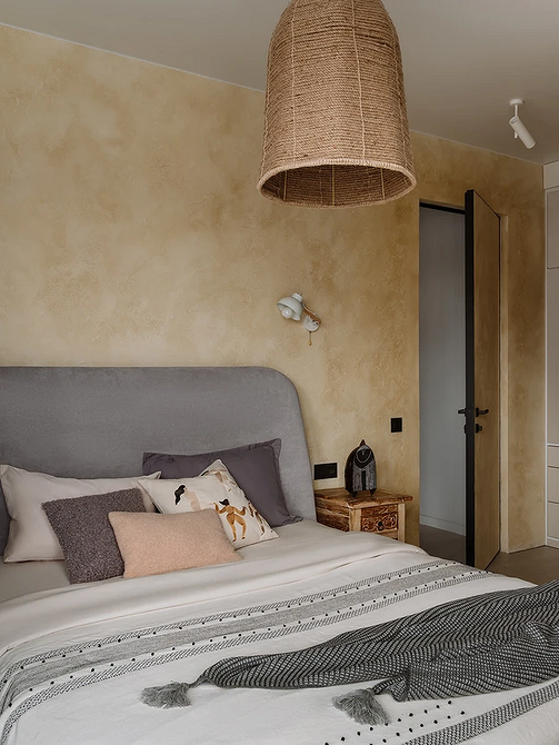 Метал і сірий: стиль Сіре ліжко з металевим каркасом та яскравими подушками в сучасній спальні.