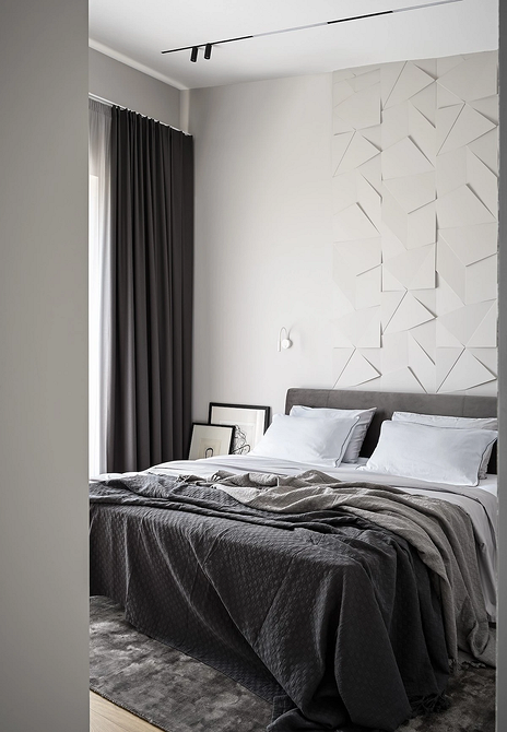 Затишок та релакс Затишна спальня з сірим ліжком, м'яким освітленням та дерев'яними елементами для релаксу.