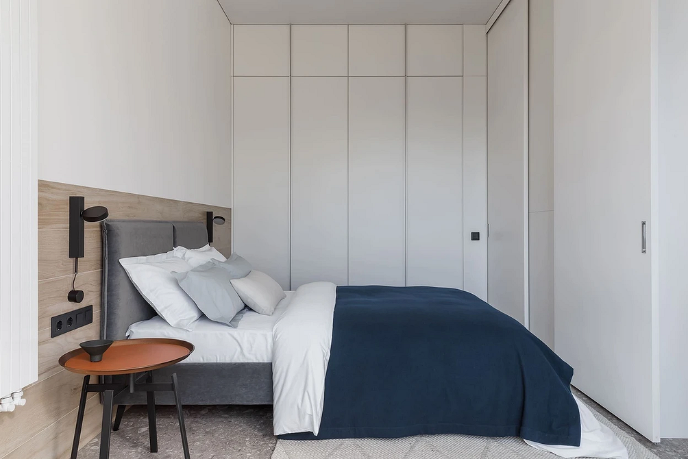 Мінімалістичний сон Сіре ліжко з м'яким узголів'ям в мінімалістичній спальні для спокійного сну.