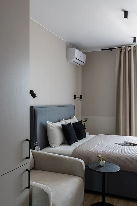 Сіра спальня: комфорт Велика спальня в сірих тонах з сірим ліжком та дерев'яними тумбочками.