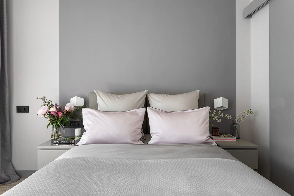 Стиль в деталях Стильна спальня з сірим ліжком, декоративними подушками та пледом, що додають шарму.