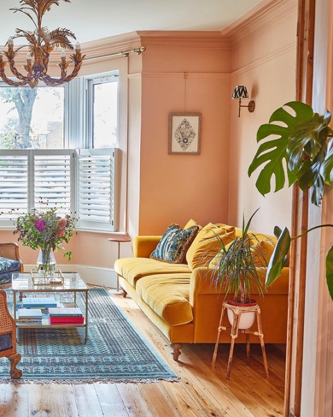 Жовтий диван в інтер'єрі Елегантний жовтий диван в світлому інтер'єрі з білими стінами та рослинами.