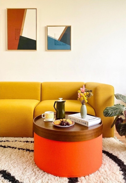 Кутовий жовтий диван Сучасний жовтий кутовий диван з дерев'яними елементами в просторій вітальні.