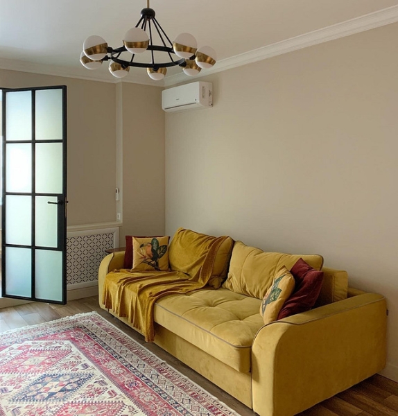 Жовтий, рожевий, сірий Жовтий диван у кімнаті з рожевими та сірими акцентами в сучасному стилі.