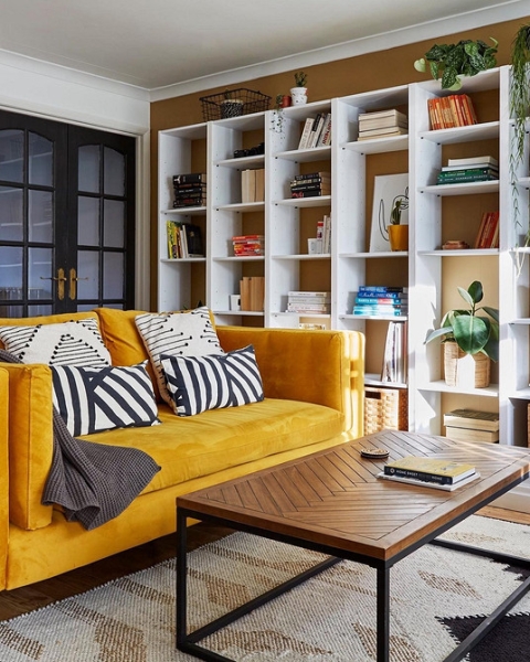 Жовтий диван, темні стіни Жовтий диван в інтер'єрі з темними стінами створює затишний контрастний вигляд.