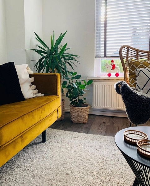 Велюровий диван жовтий Жовтий велюровий диван в елегантній вітальні з розкішною люстрою.