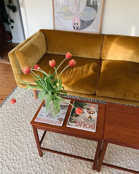 Яскравий жовтий акцент Яскравий жовтий диван з білими стінами у вітальні, свіжий та сонячний інтер'єр.