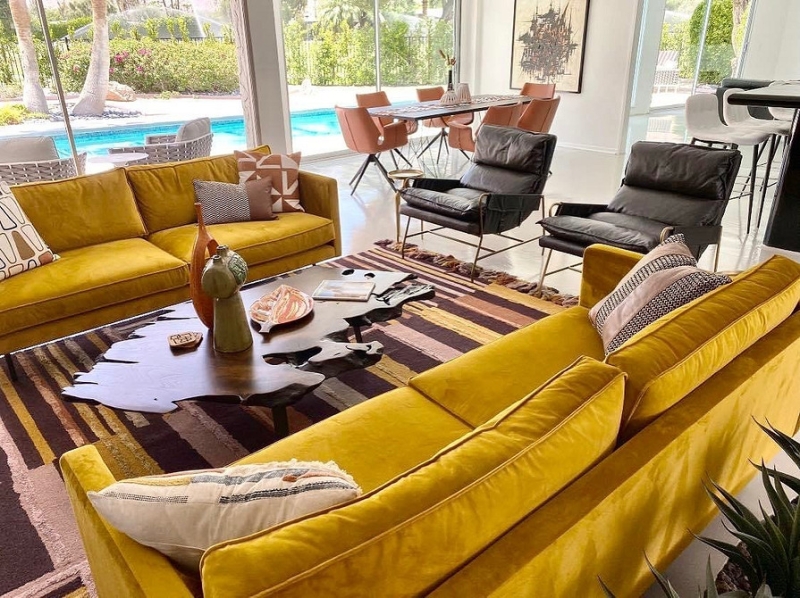 Жовтий диван з подушками Затишний жовтий диван з геометричними подушками у світлій вітальні.