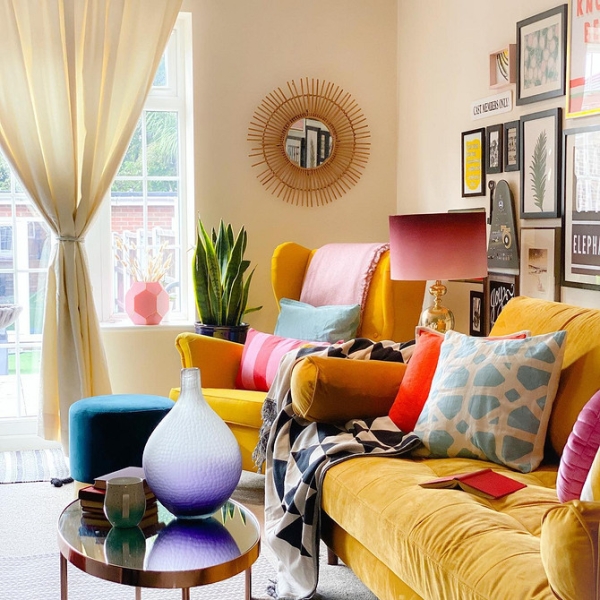 Великий жовтий диван Великий жовтий диван у просторій вітальні з килимом та декоративними подушками.